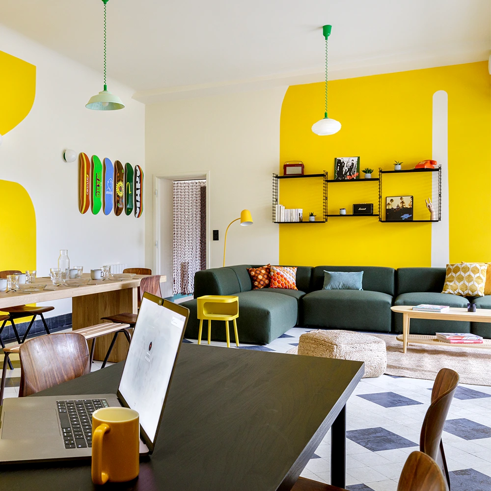 a room with a couch and a table with a laptop on it